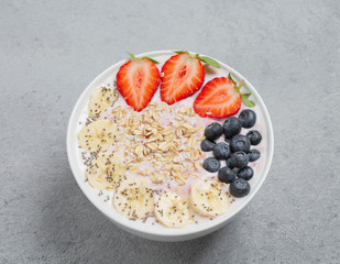 Healthy Breakfast smoothie bowl with strawberries, blueberries, banana, granola and Chia seeds.