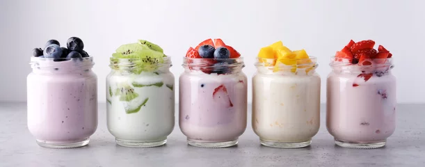 Fotobehang Variety of yogurts in glass jars. Healthy Breakfast Concept. Banner Photography © Anna Puzatykh