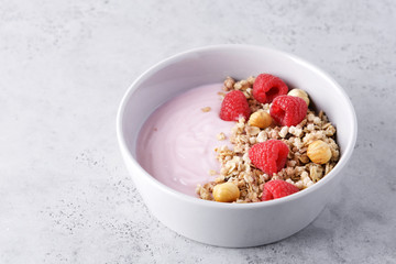 Raspberry yogurt with granola in a bowl. Nutritious snack or breakfast
