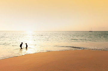 Asian boys playing on the sunset beach.