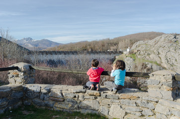 Naklejka premium little kids enjoying the landscapes views in the mountains of Palencia, Spain, during the winter ending and the spring beginning in a warm sunny day