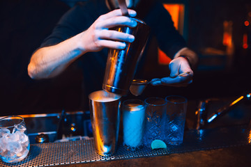 Bartender pouring using strainer White pink healthy Cocktail drink on a bar counter . Bartender...