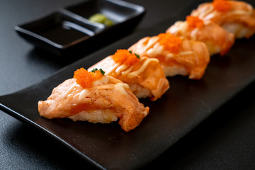 grilled salmon sushi on black plate