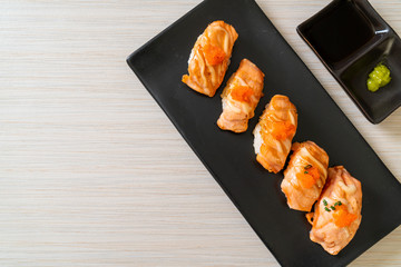 grilled salmon sushi on black plate