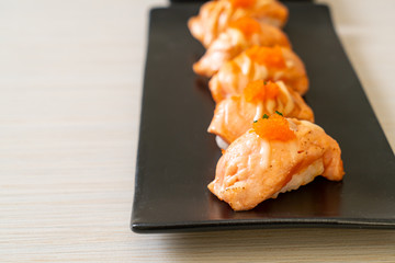 grilled salmon sushi on black plate