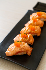 grilled salmon sushi on black plate