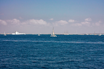 Some sailboats and yachts in the sea between Ibiza and Formentera in the Balearic islands in Spain.