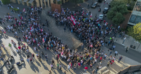Beirut Lebanon 2019: Aerial drone shot of protesters at Martyrs Square facing the police and wires blocking the road while more protesters join from the other side of the road during the revolution