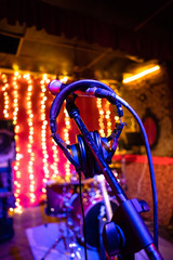 Micrófono y auriculares, instrumentos musicales preparados en escenario, luces listo