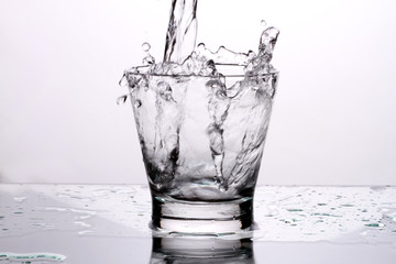 Close up pouring purified fresh drink water from the bottle on table in