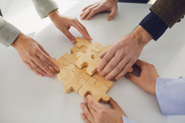 Faceless business people placing puzzles idea together
