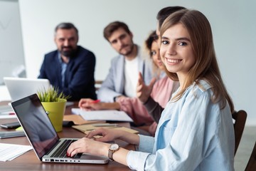 Obraz premium Beautiful business lady is looking at camera and smiling while working in office