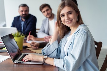 Obraz premium Beautiful business lady is looking at camera and smiling while working in office