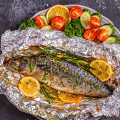 Mackerel baked in foil with vegetables on a dish