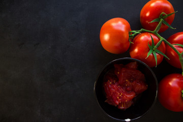 Red tomato and a bowl of chopped tomatoes