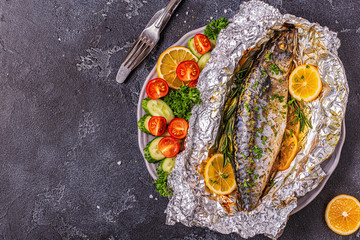 Mackerel baked in foil with vegetables on a dish