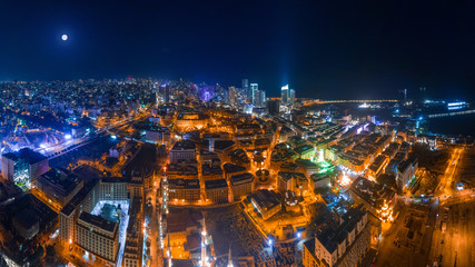 Fototapeta premium Bejrut, Liban 2019: Panoramiczne ujęcie lotnicze z drona centrum Bejrutu na pierwszym planie i panoramę miasta w noc pełni księżyca.