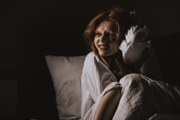 female smiling devil in nightgown sitting in bed