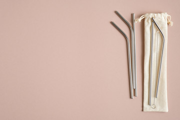 Stainless steel drinking straws with cleaning brush and case on brown background. Zero waste, plastic free concept