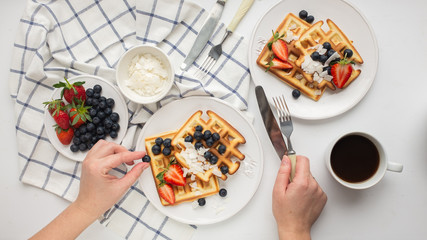 Beautiful breakfast: Viennese Belgian waffles decorated with berries, a plate with strawberries and blueberries