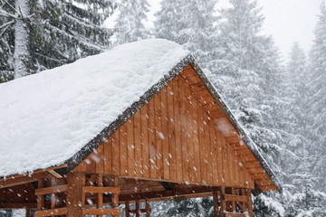 Modern wooden gazebo on snowy day. Winter vacation