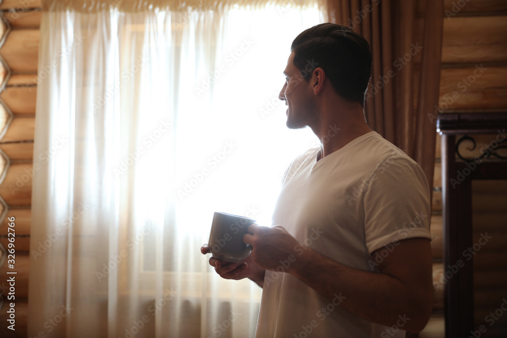 Sticker Man with drink near window indoors. Lazy morning