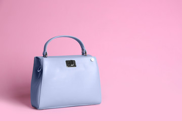 Stylish woman's bag on light pink background. Space for text