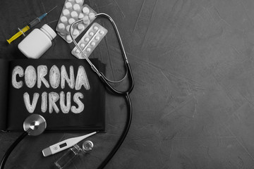 Notepad with words CORONA VIRUS, stethoscope and medicines on grey stone background, flat lay. Space for text