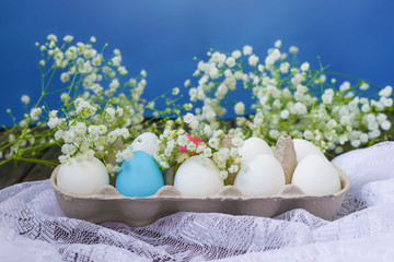 Happy Easter. White eggs in a stand on a wooden background with white gypsophila flowers. Holidays...