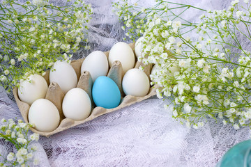 Happy Easter. White eggs in a stand on a wooden background with white gypsophila flowers. Holidays...