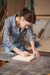 Close up carpenter girl in glasses with tape measure and blackboard