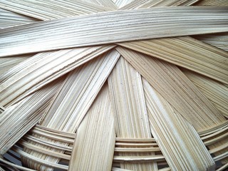 part of a basket woven from a vine in warm beige tones. A basket made of wood chips or bast