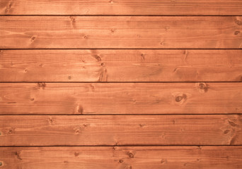 Background from a wooden pine lining of red-brown color with small knots. Horizontally located planks docked to each other in a castle. Vintage old texture