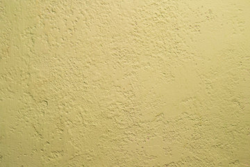 Dark yellow old stucco painted with paint. Uneven and not uniform vintage putty texture. Background.
