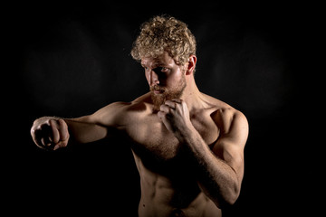 Beautiful muscles, athletic body. Studio photography on a black background, naughty light. Combat...