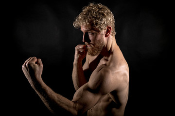 Beautiful muscles, athletic body. Studio photography on a black background, naughty light. Combat...