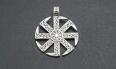 Swastika. Slavic or Scandinavian amulet "Kolovrat" or the solstice "," Ladin "Pagan talisman, a symbol of the sun. On a black background. Close-up shot of excellent quality.