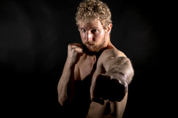 Beautiful muscles, athletic body. Studio photography on a black background, naughty light. Combat...