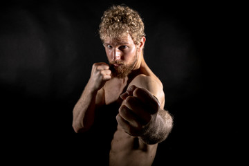 Beautiful muscles, athletic body. Studio photography on a black background, naughty light. Combat...