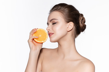 Obraz na płótnie Canvas Woman closed her eyes and inhales aroma orange. Mandarin stimulates immune defense, contributes to weight loss and improves mood. Citrus fights against aggressive environmental factors.