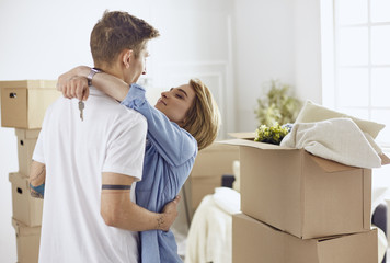 Fototapeta premium Happy smiling young couple showing a pair of keys of their new house
