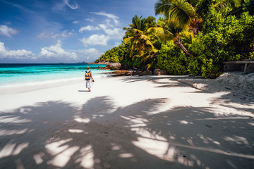 Female tourist enjoy vacation on tropical island with white sand beach, palm trees and blue ocean...