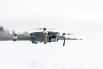 Running drone into the sky, quadcopter on blue sky background.