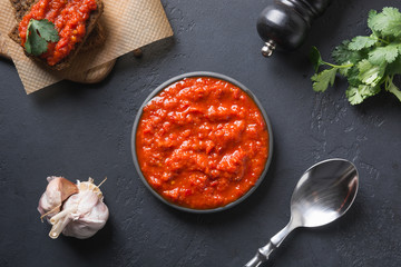 Tasty ajvar. Vegetable sauce or caviar of baked red bell pepper on black. Balkan cuisine.