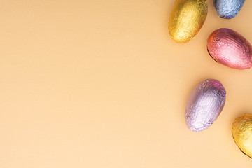 Top view of chocolate Easter eggs on beige background