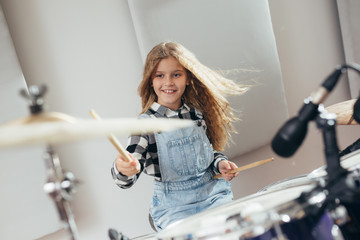 young girl playing drums at the music studio