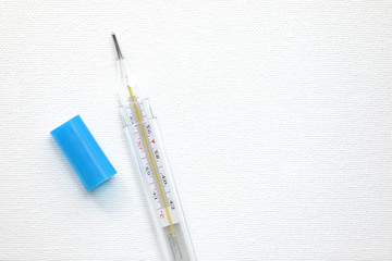 Thermometer and pills on a white background.
