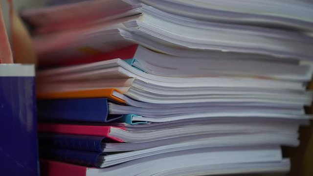 Stack of papers documents in archives files with clip papers on table at offices, Busy offices and Pile of data unfinished folders on office desk indoor near window, Business concept.