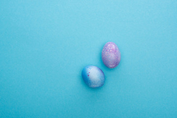Top view of colorful chicken eggs on blue background