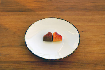 A white plate with heart-shaped chocolate candy